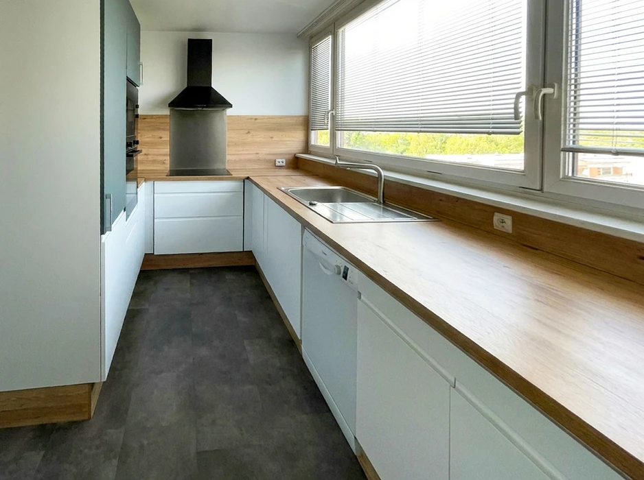 Cuisine moderne équipée en L, vide et lumineuse