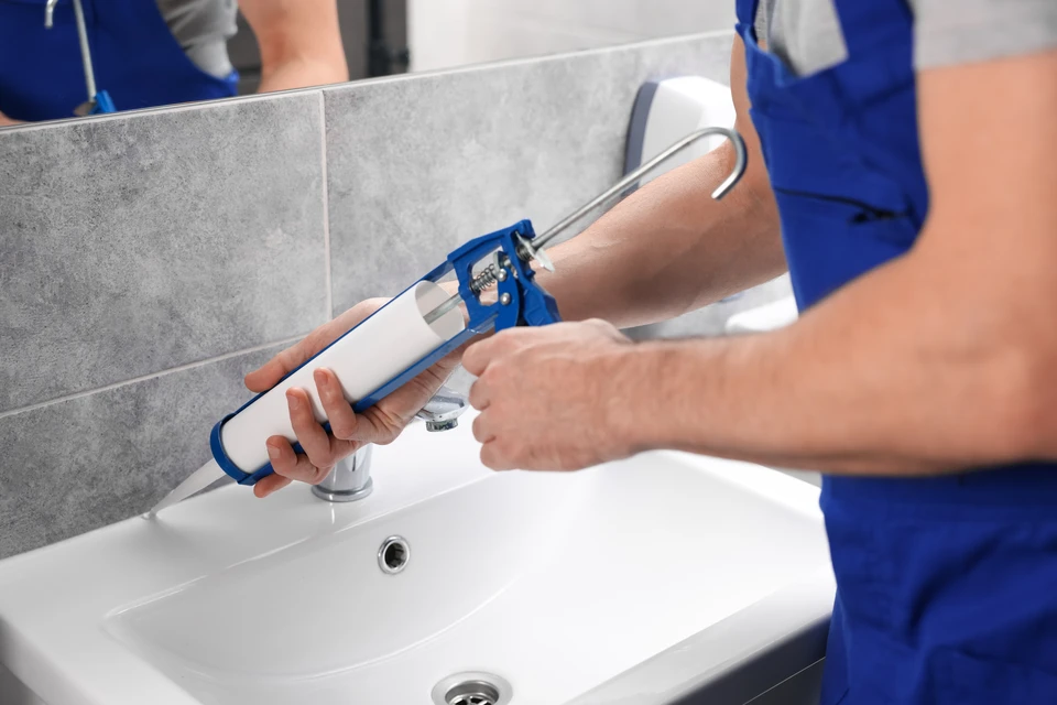 Ouvrier en construction appliquant des panneaux d'isolation thermique sur mur extérieur